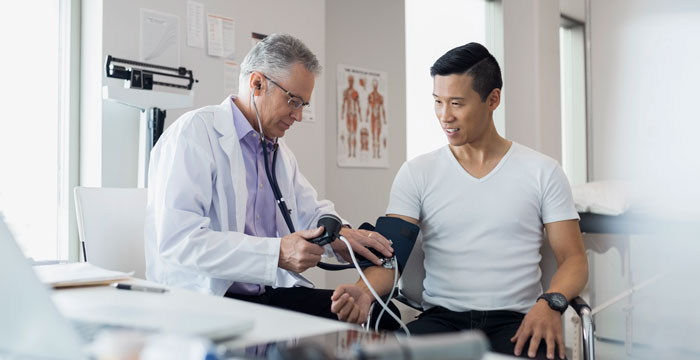 doctor taking patient's blood pressure